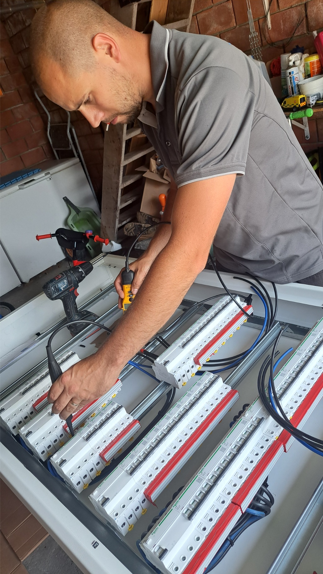 Matthias de zaakvoerder van MVW electrics die een zekeringskast aan het plaatsen is